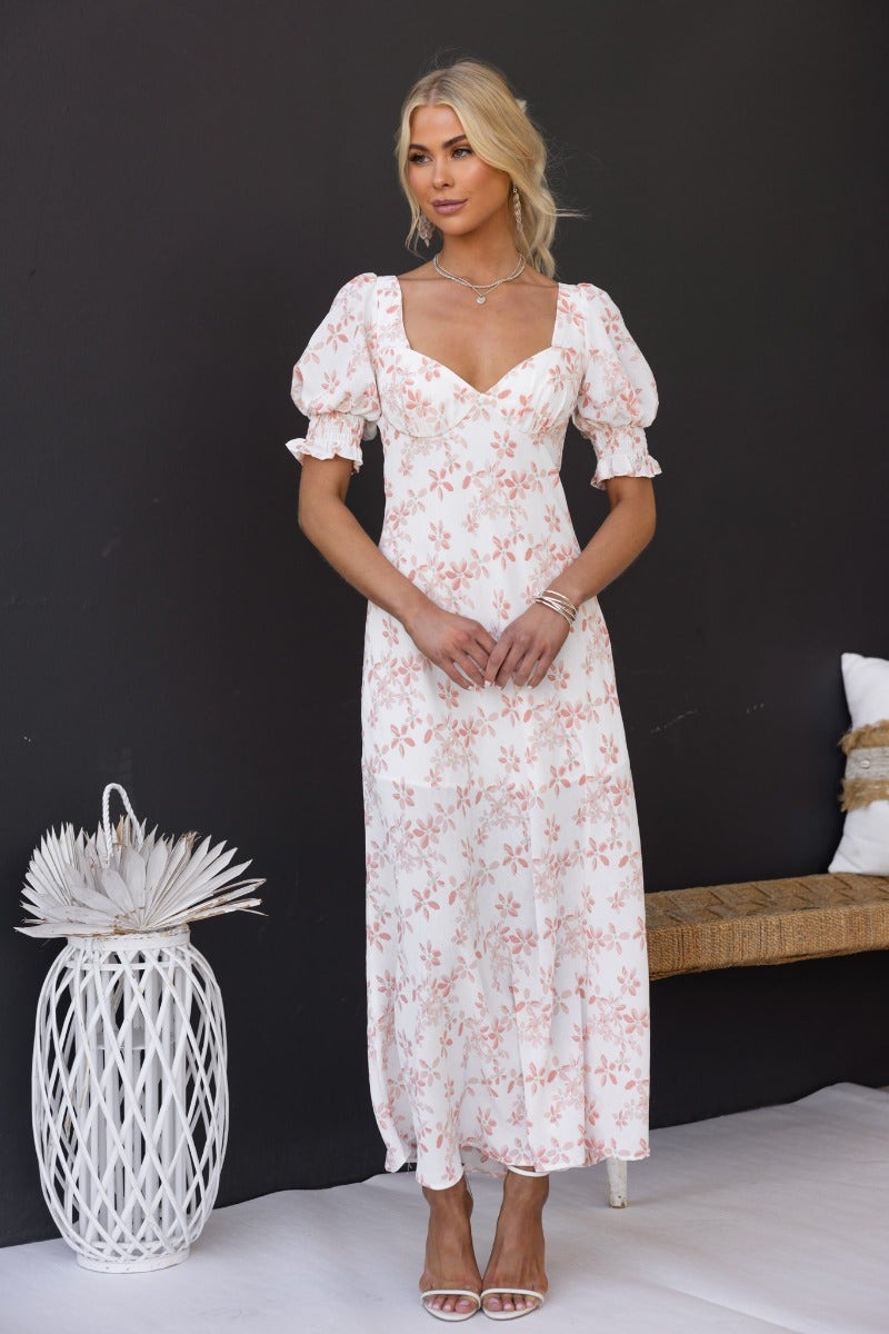 Model wearing the Have A Moment Maxi Dress, a floral print dress with elastic sleeves and open back detail.