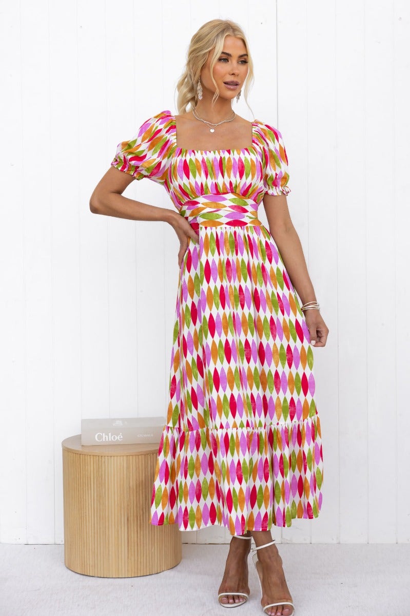 Garland Midi Dress with multi-colour print, sweetheart neckline, elastic sleeves, and pockets, modeled by a woman.
