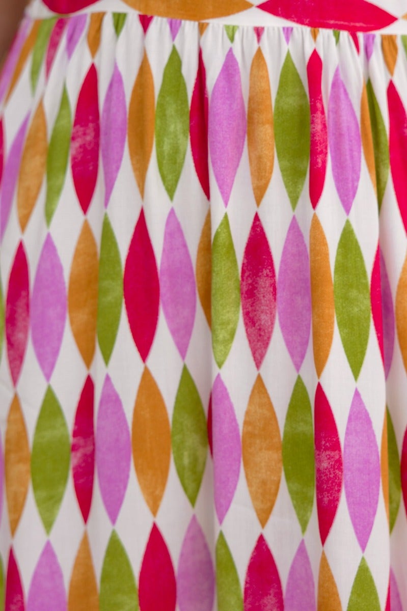 Colorful diamond pattern of multi-colour print on a midi dress featuring pink, green, orange, and white.