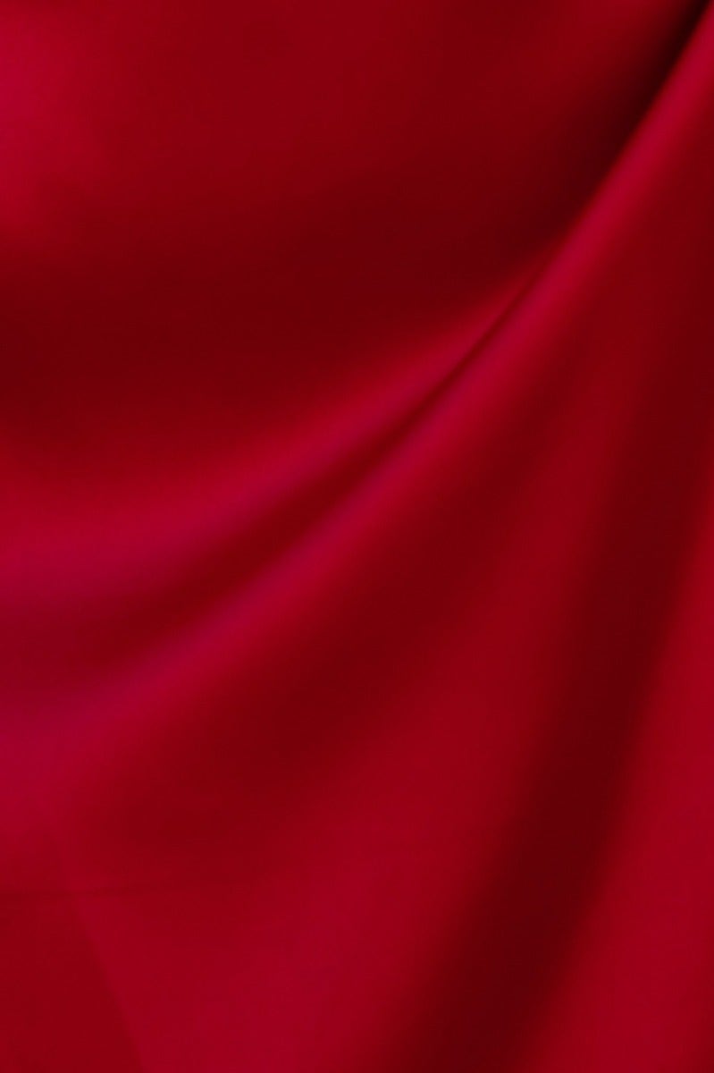 Close-up of smooth red satin fabric showcasing its luxurious texture and rich color.
