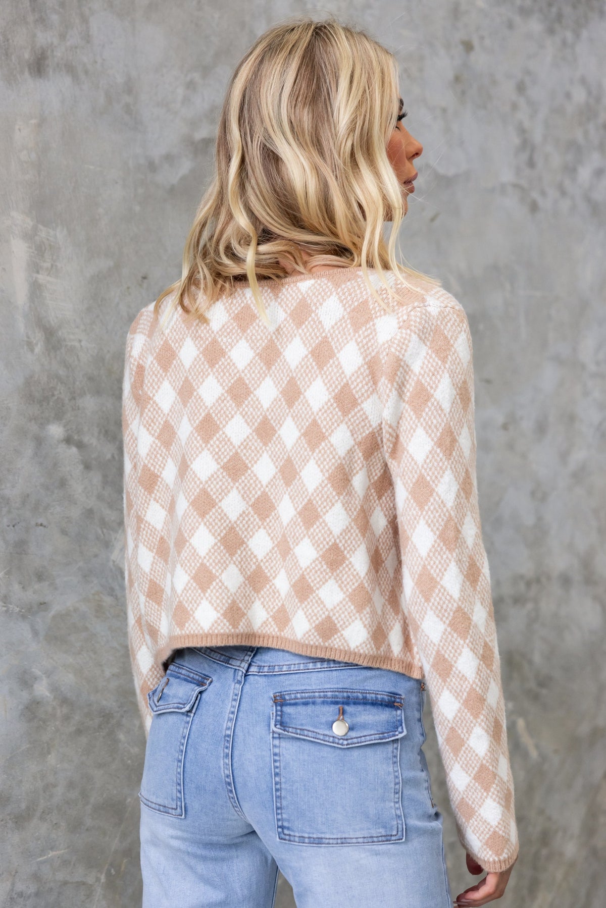 Back view of Addie Cardigan in a checked pattern, paired with light blue jeans, showcasing its stylish crop fit.