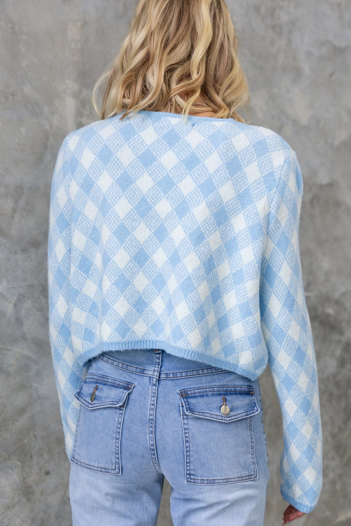 Back view of a light blue and white checkered Addie Cardigan paired with light wash jeans.