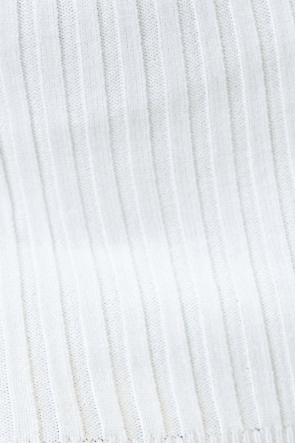 Close-up of the ribbed knit fabric used in the Stassie Dress, showcasing its stretch and texture in a soft white color.