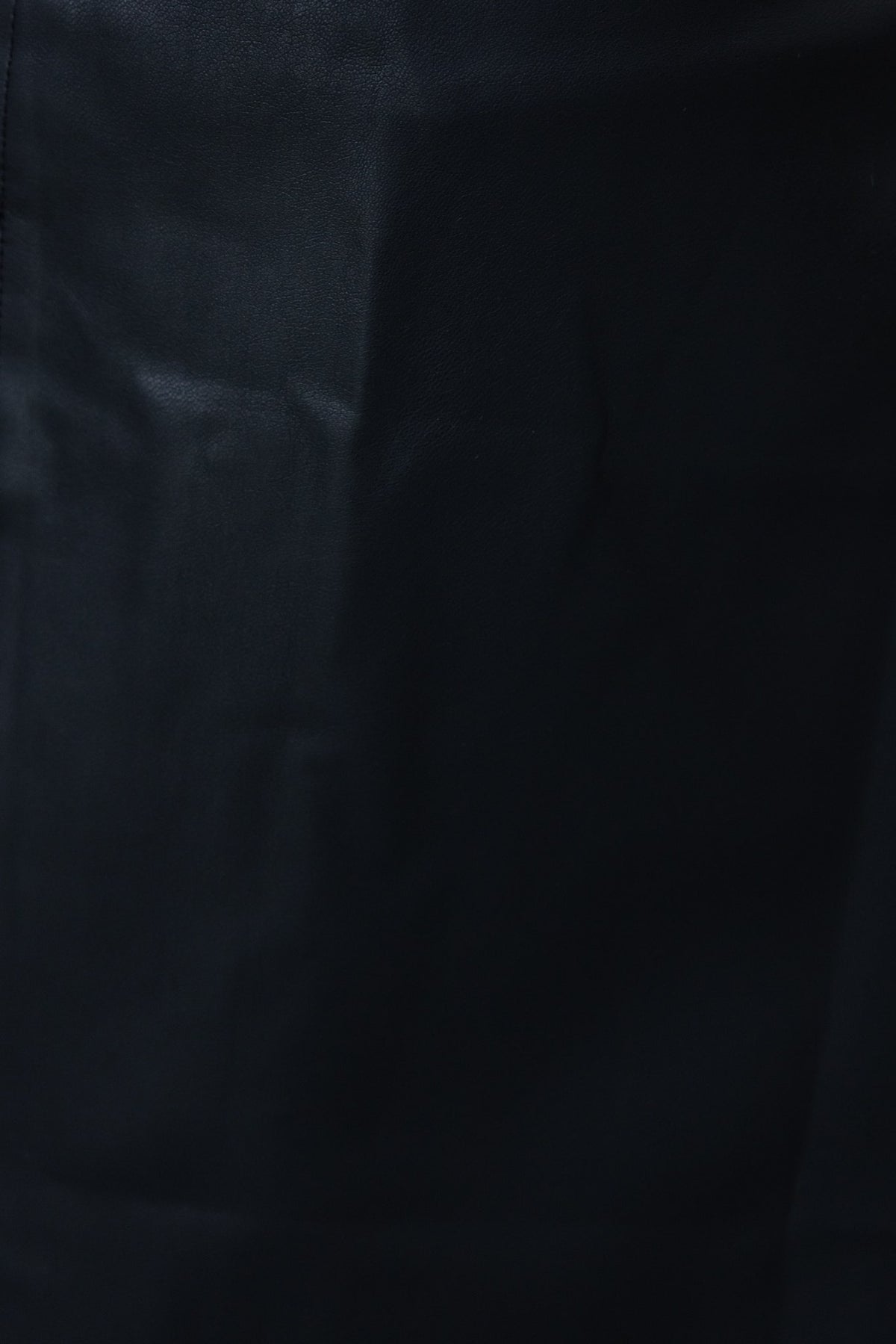 Close-up of a black faux leather fabric, showcasing texture and sheen of the Jaune Maxi Skirt.