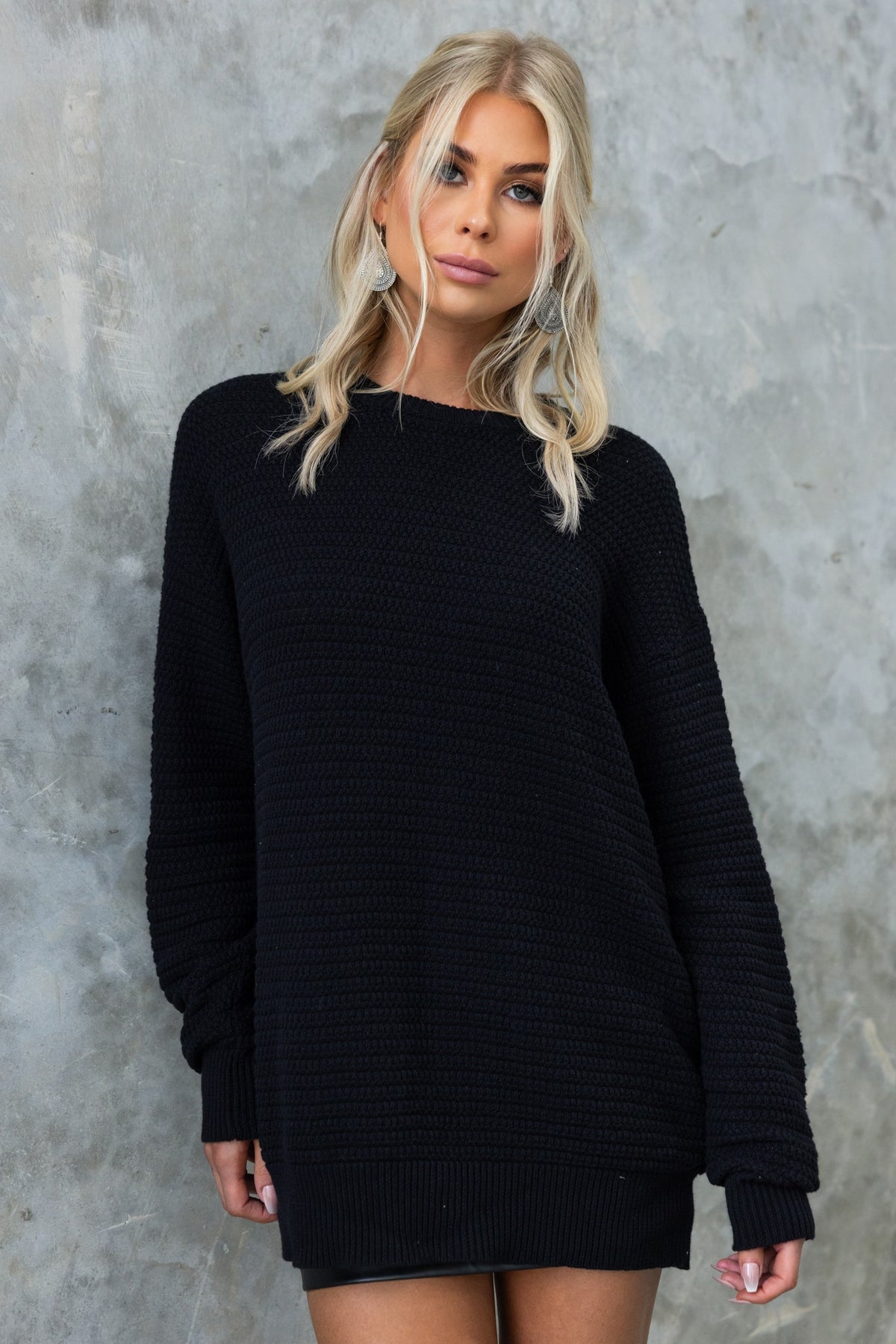 Model wearing a relaxed fit black knit Rhode Jumper with round neckline and long sleeves.