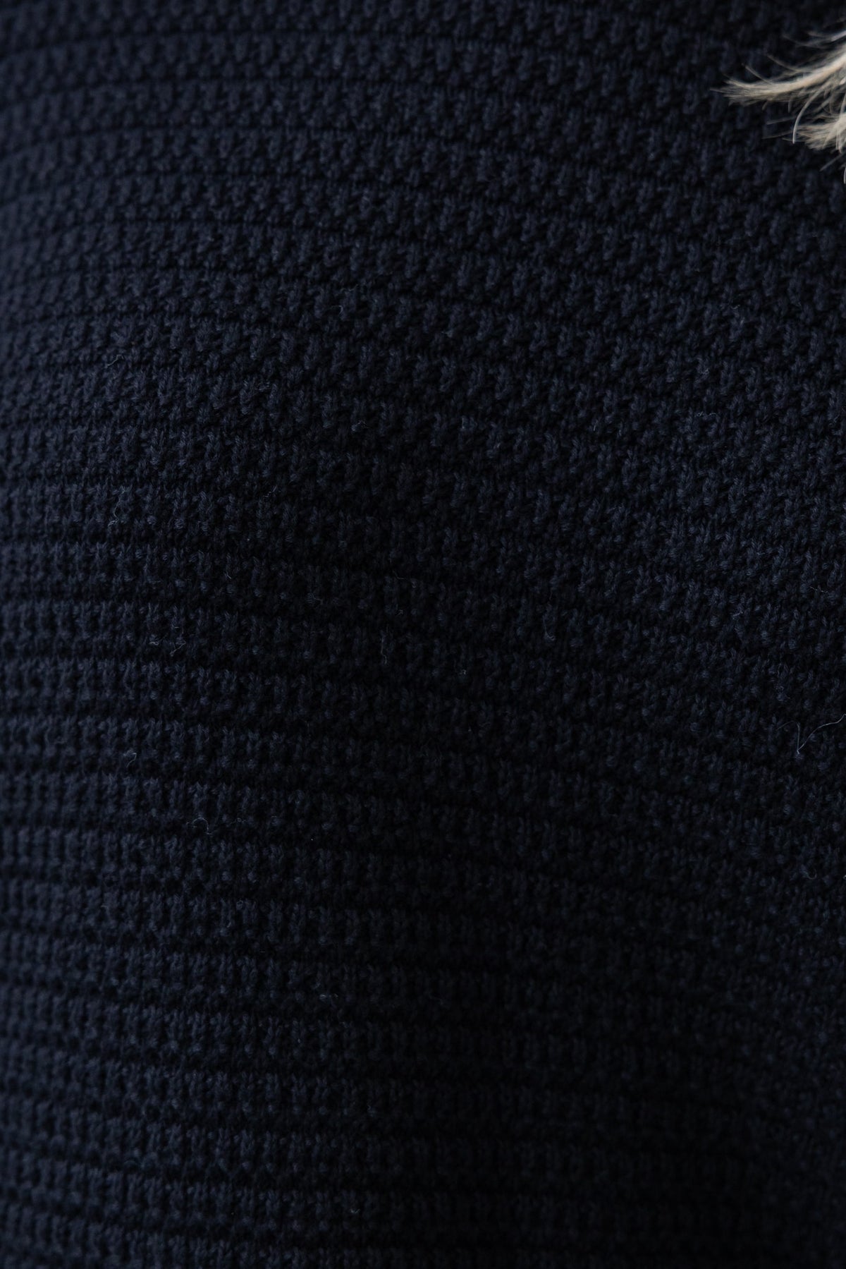 Close-up of the textured knit material of a black Rhode jumper, highlighting its softness and stretch.