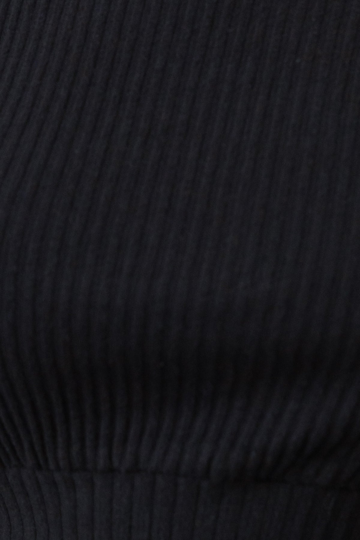 Close-up of black ribbed fabric showing texture for Mehki Shorts with elastic waistband.