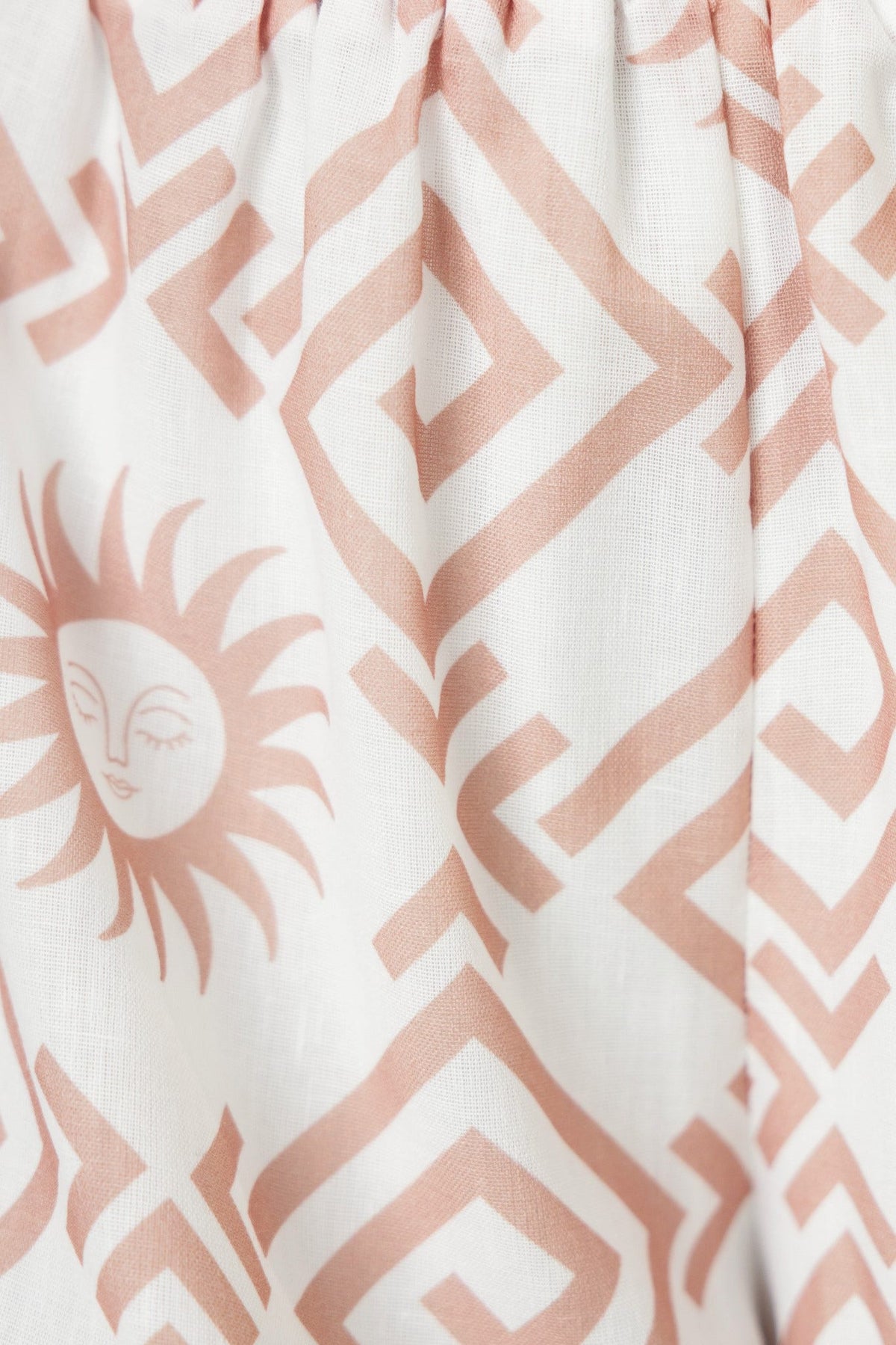 Close-up of a Take It Easy Shirt featuring a pink geometric pattern with a sun motif on a light background.