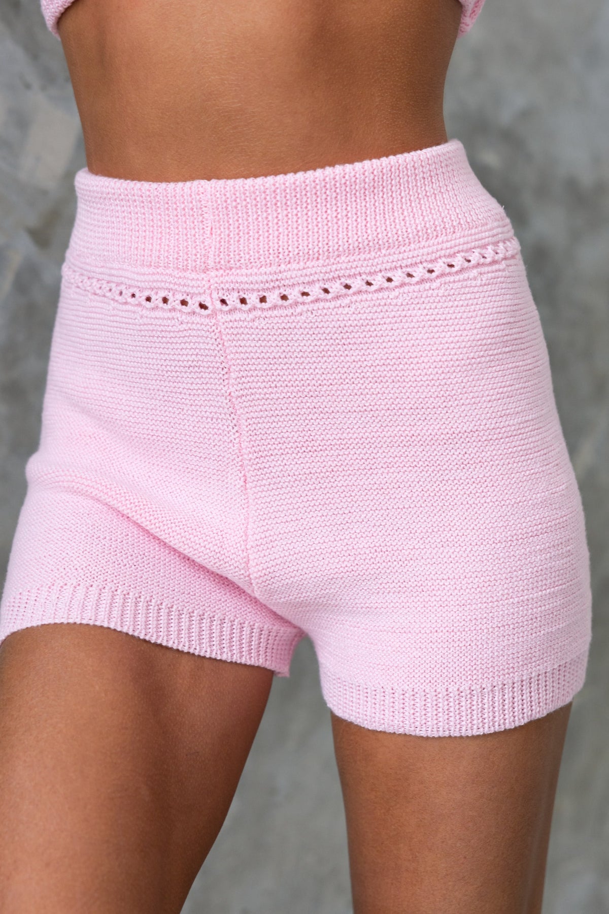 Pearla Shorts in light pink, featuring a mid-high waist, elastic waistband, and semi open weave knit material.