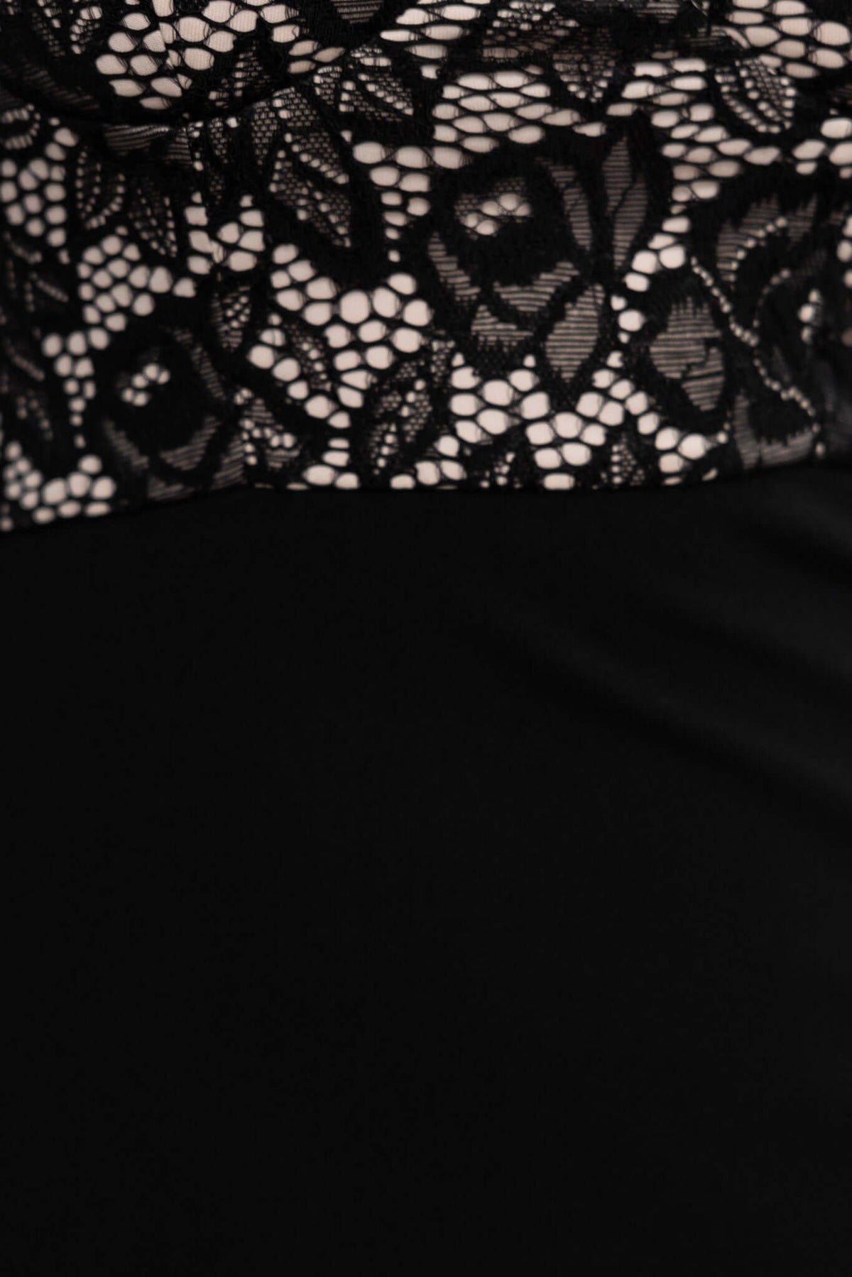 Close-up of black maxi dress featuring intricate lace detailing and smooth fabric for a chic look.