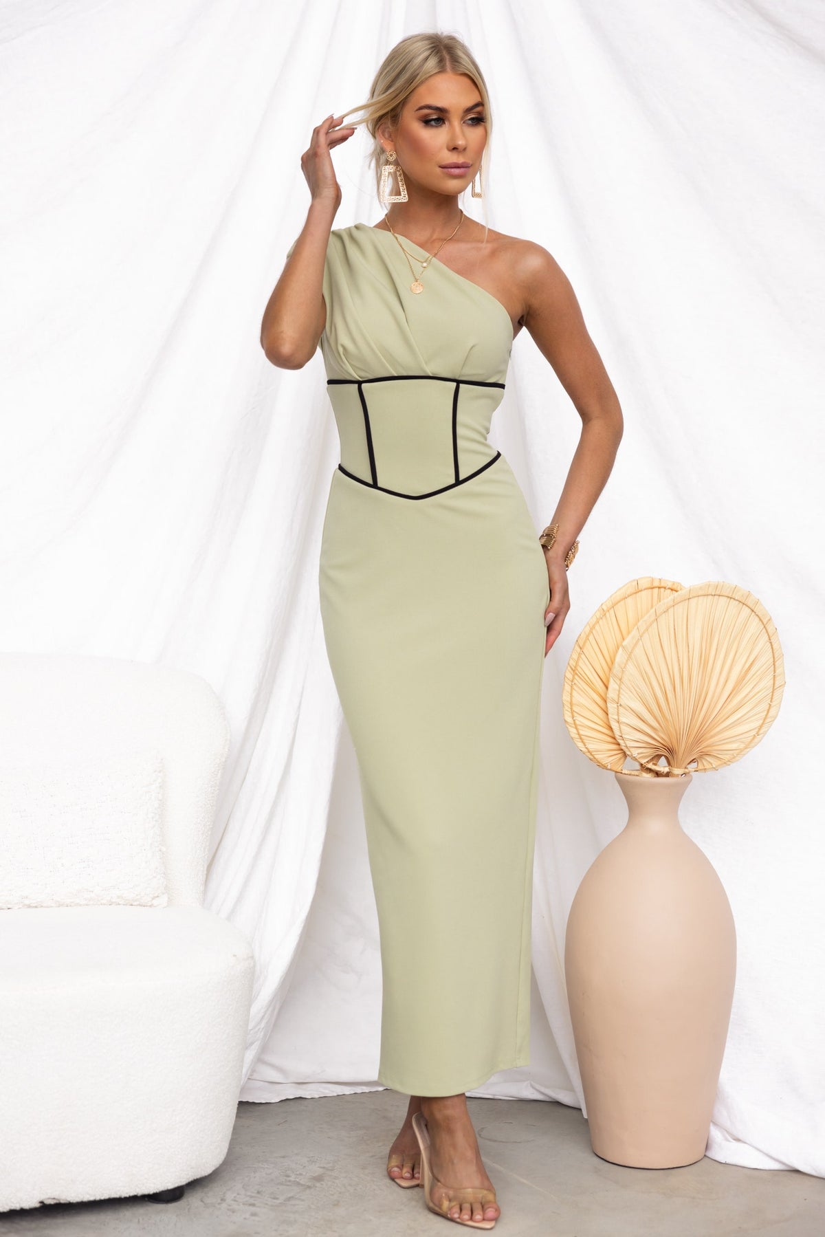 Model in a one-shoulder maxi dress with a fitted waist and side zip, showcasing a stylish and elegant look.