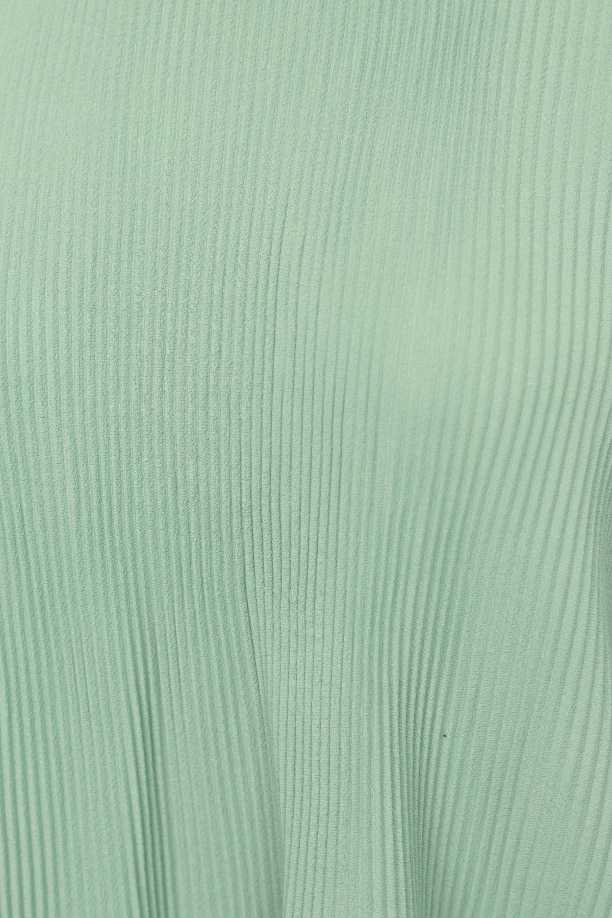 Close-up of Barbara Top in mint green, featuring pleated texture and stretchy fabric.