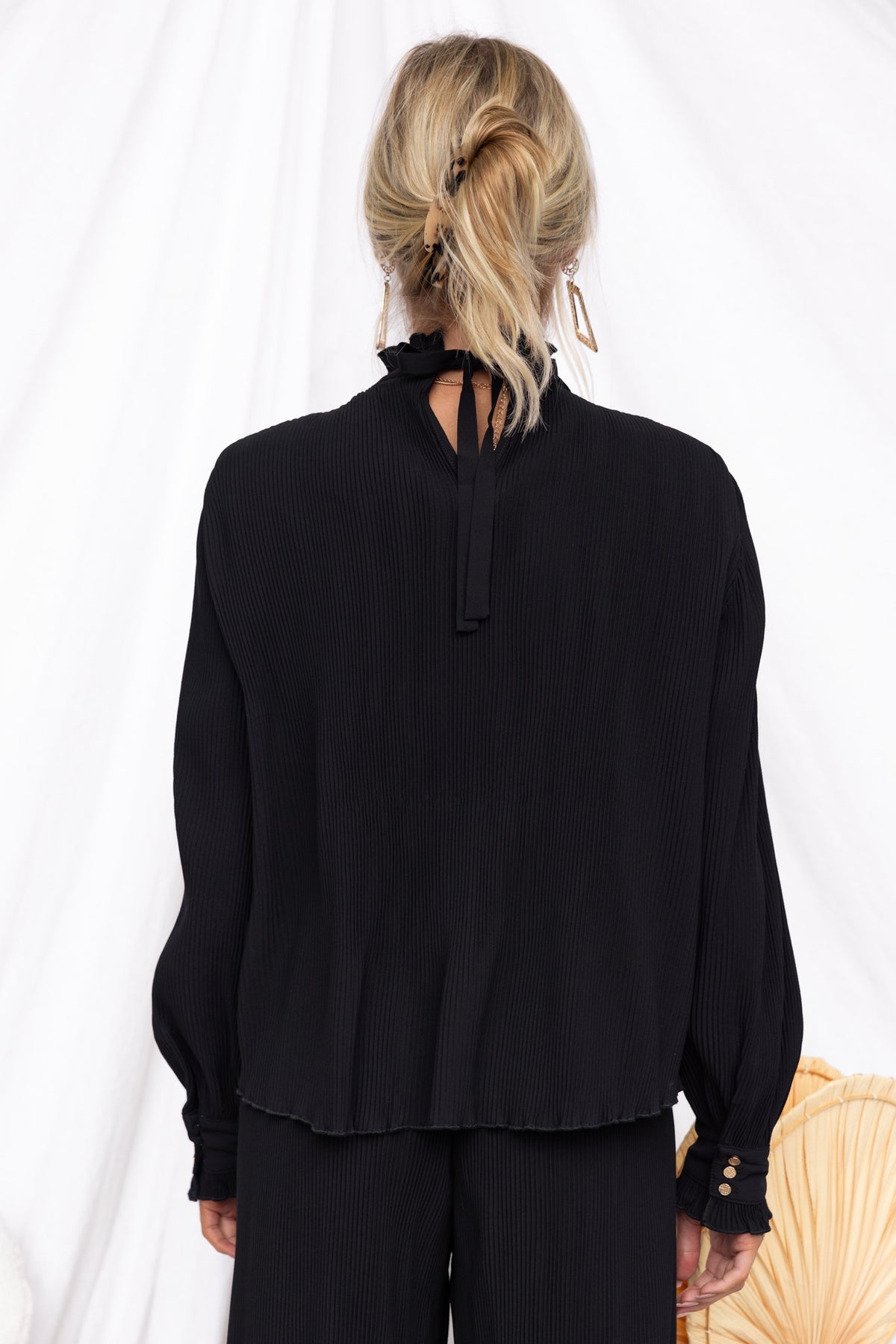Back view of the Barbara Top in black with pleated material and tie detail at the neck, perfect for a stylish, relaxed fit.
