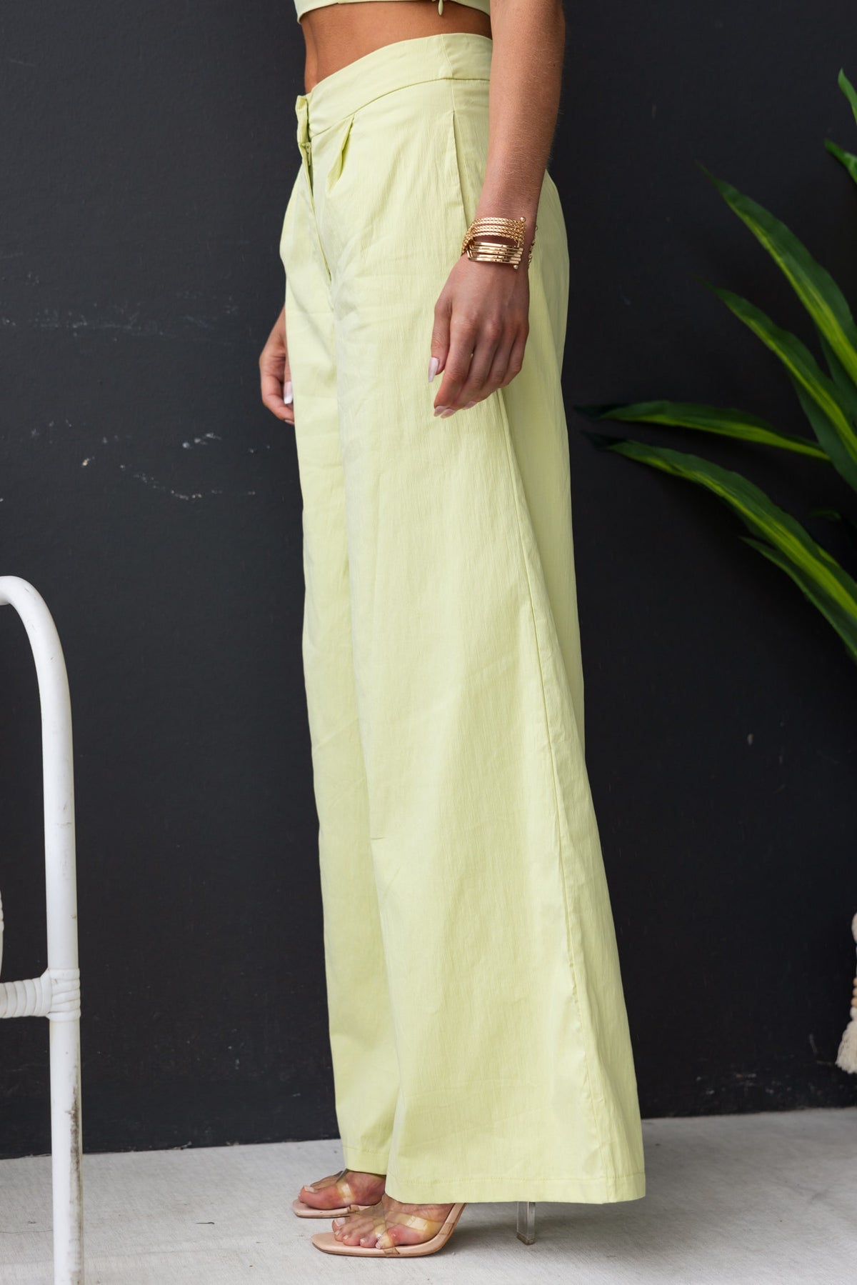 Model wearing Janae Pants, light yellow, mid-high waist, featuring pockets and a cotton-like feel.