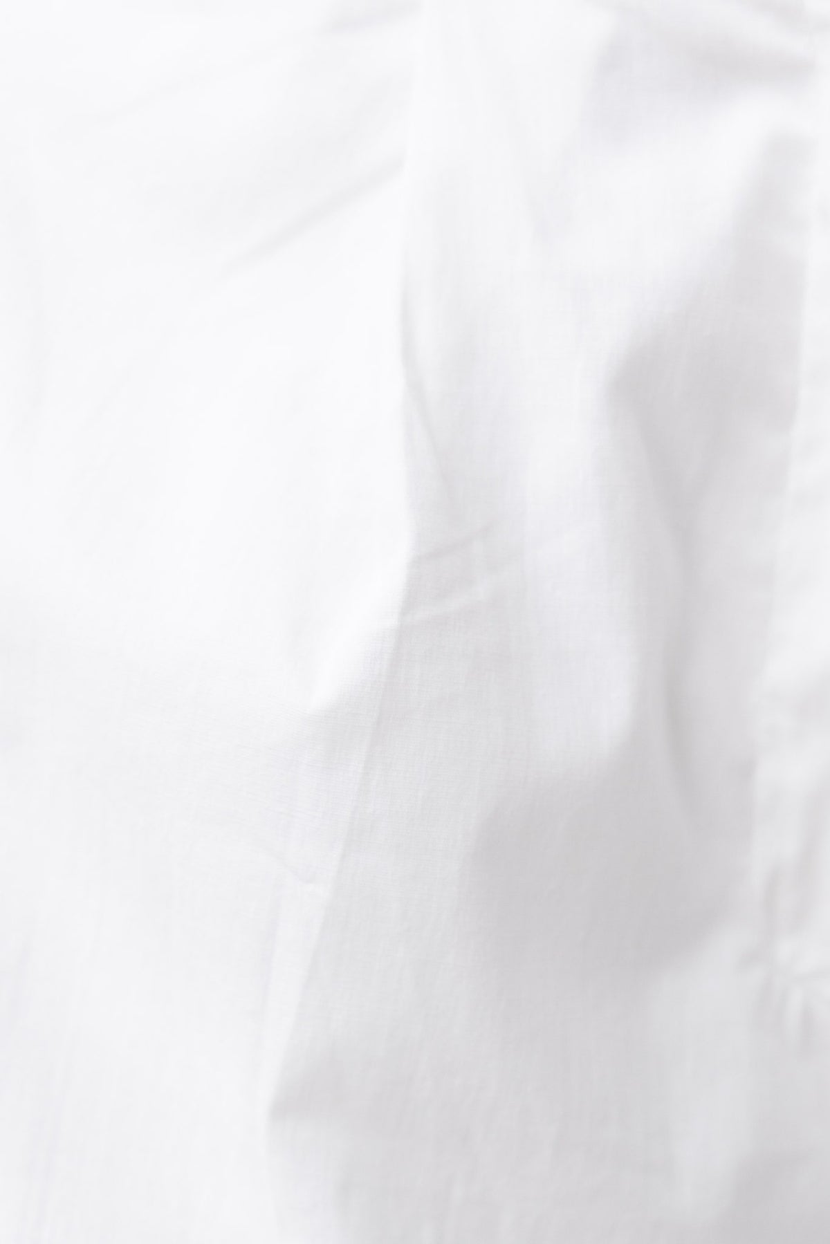 Close-up of a soft, white fabric texture, showcasing a smooth cotton look and feel.