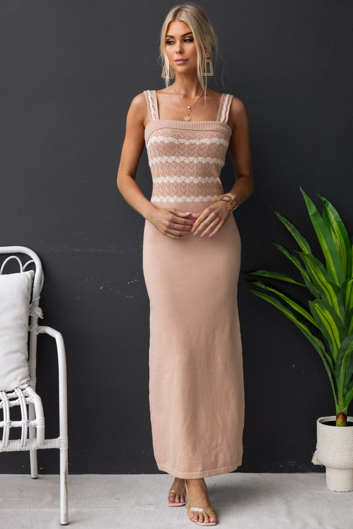 Model wearing Tarnya Maxi Dress, a stylish knit dress with fitted bodice and long skirt, against a dark background.
