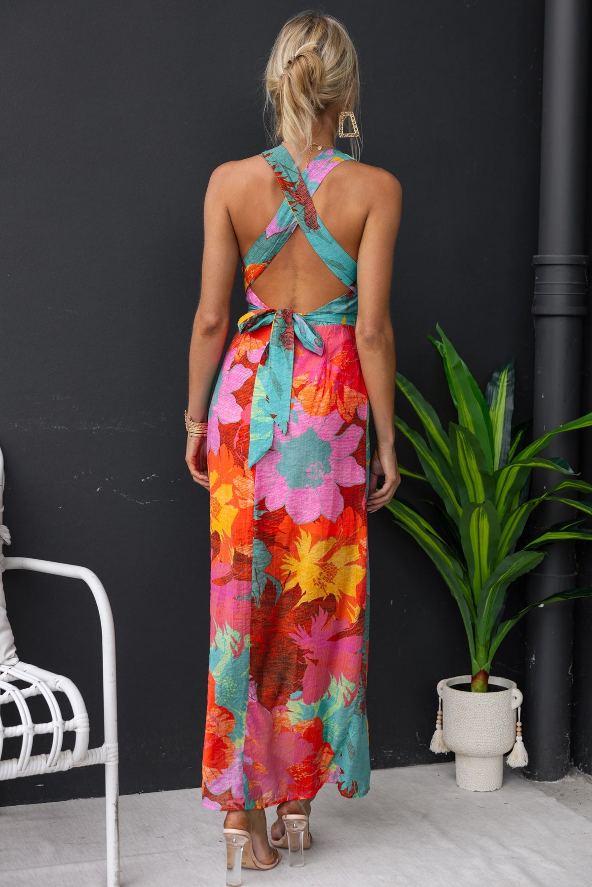 Back view of a Kyrie Maxi Dress in vibrant floral print, showcasing adjustable tie neckline and lightweight chiffon fabric.
