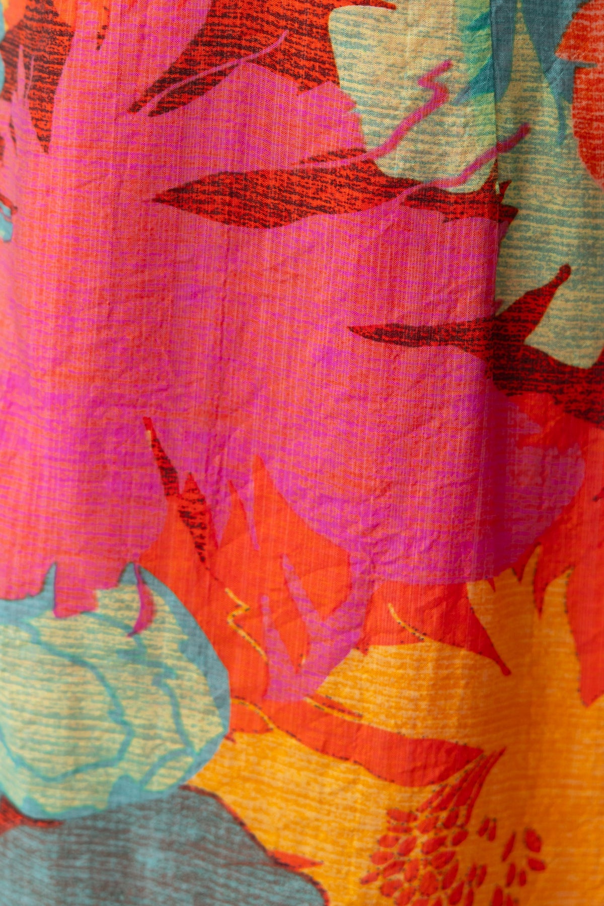 Vibrant floral pattern in pink, orange, and teal on lightweight fabric, perfect for summer maxi dresses.