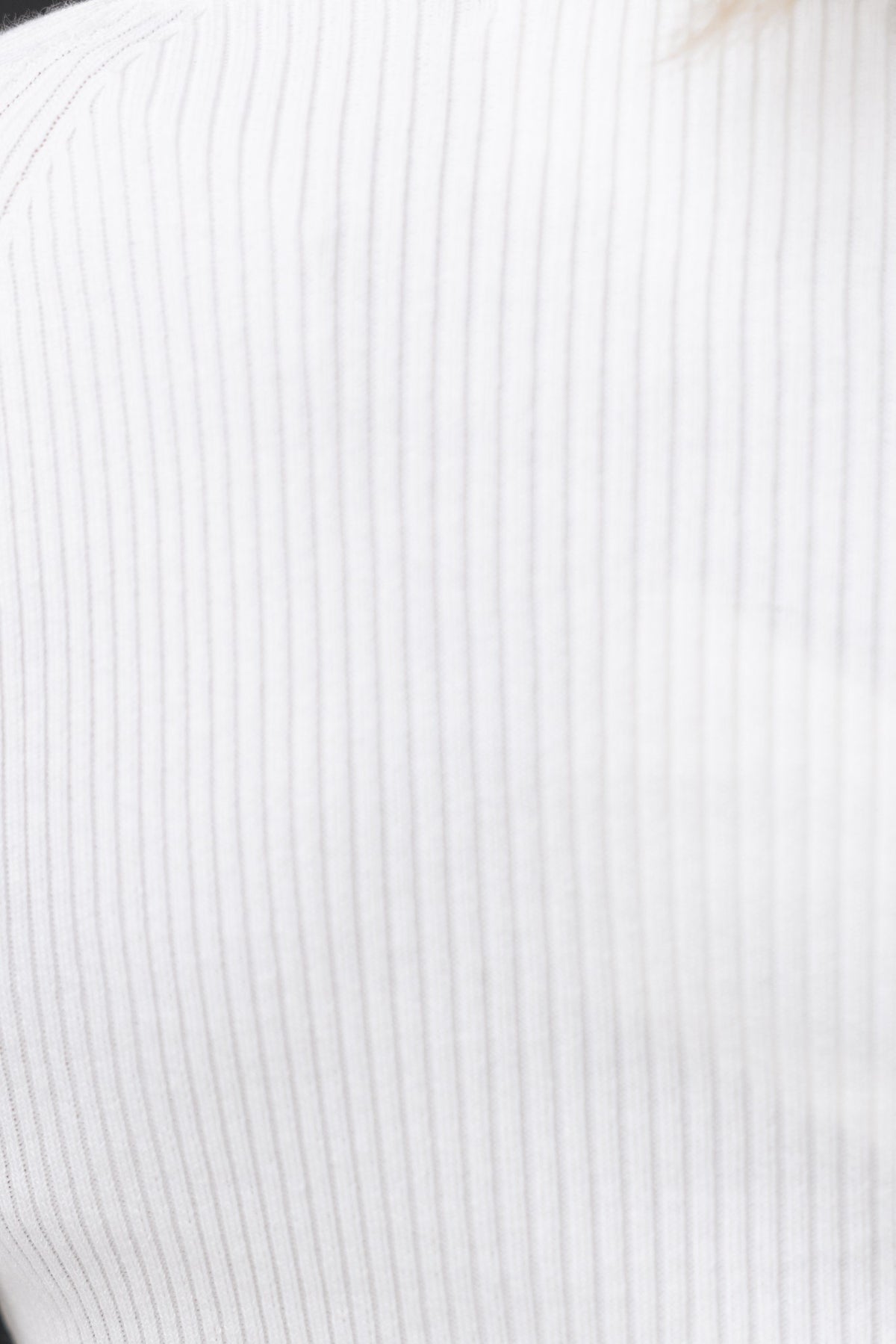 Close-up of the ribbed fabric of the Regina Top in white, showcasing its stretch and sweetheart neckline design.