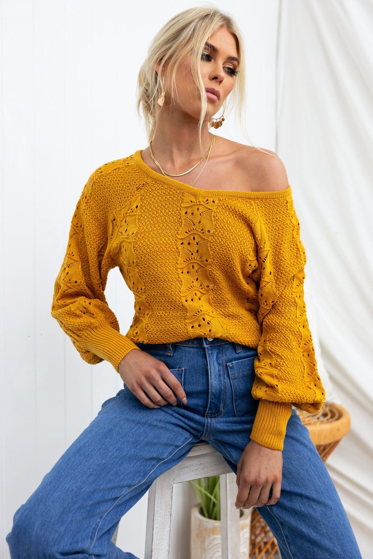 Model wearing a vibrant yellow Cadie Knit top with semi-open weave and relaxed fit, paired with high-waisted jeans.