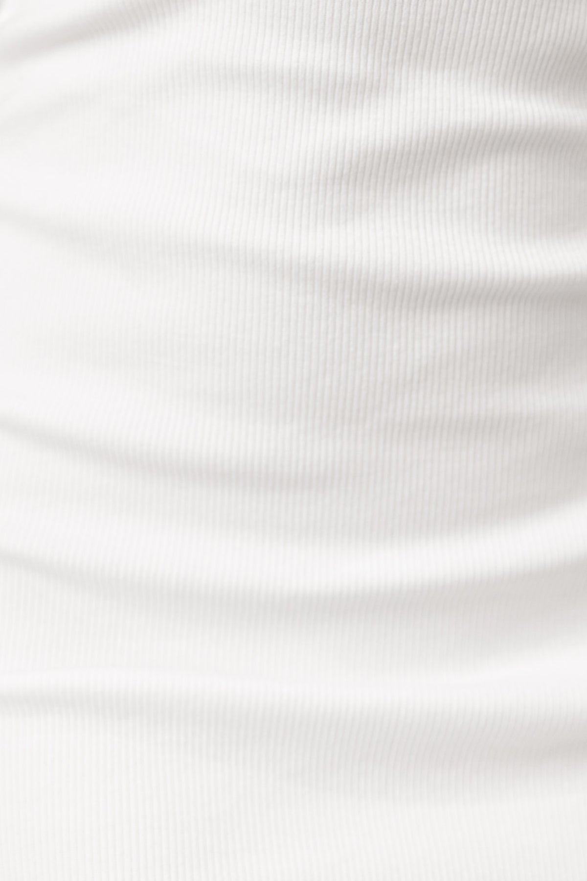 Close-up of white ribbed fabric showcasing its soft texture and stretch, ideal for stylish clothing like the Montara Midi Dress.