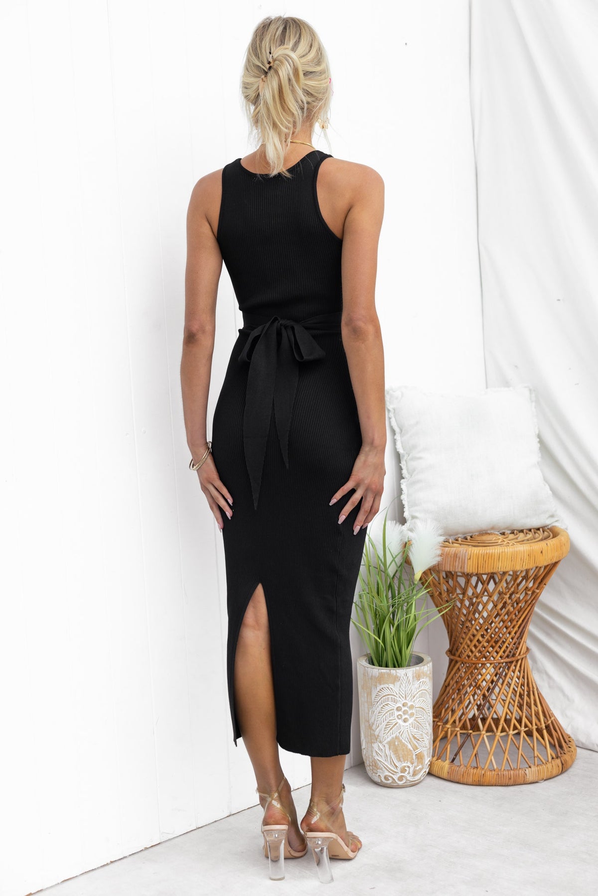 Model wearing a black Lauryn Midi Dress with a round neckline, tie detail, and back split, showcasing a stylish fit.