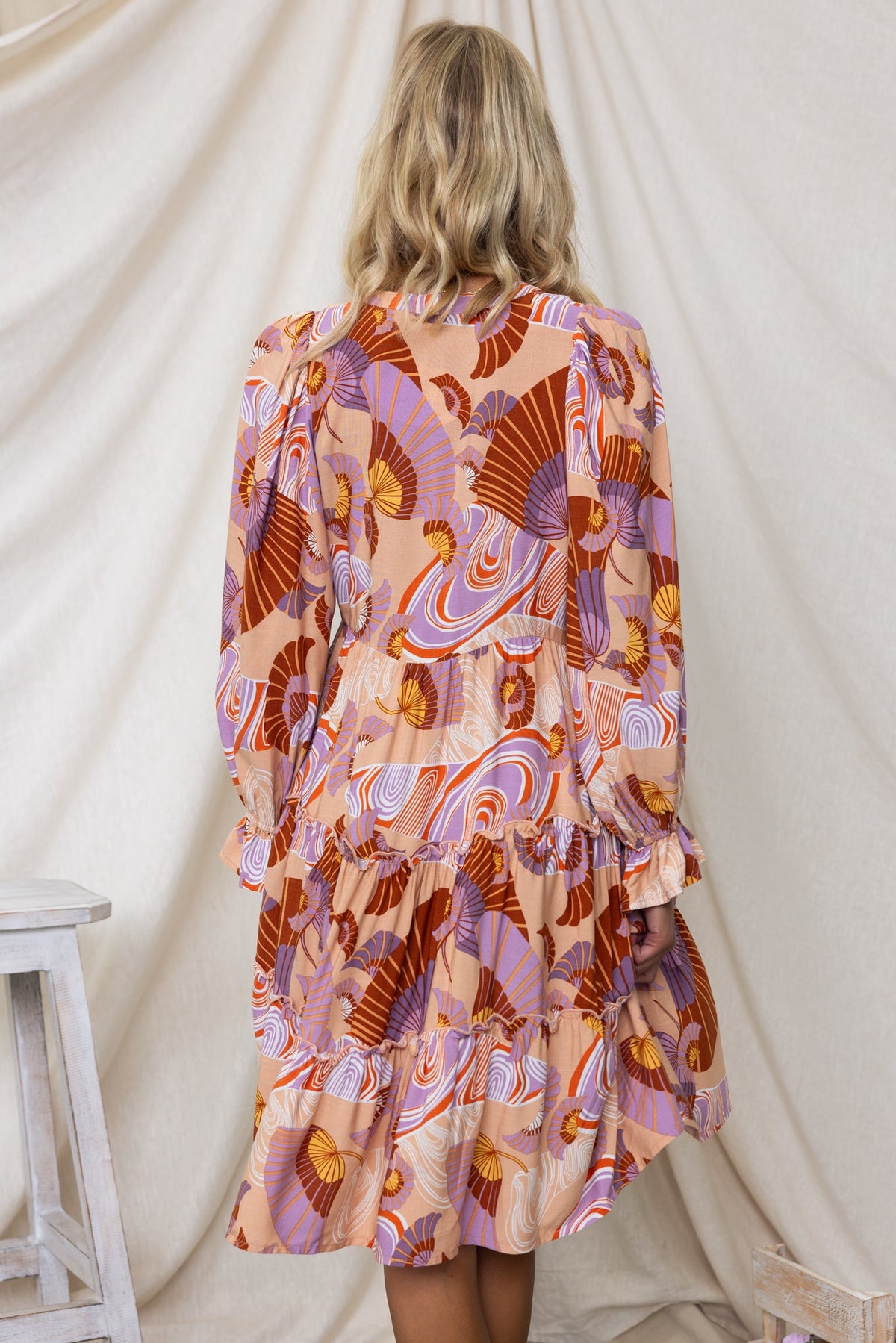 Back view of Boone Dress featuring colorful patterns, V-neckline, and elastic sleeves, perfect for a relaxed fit.