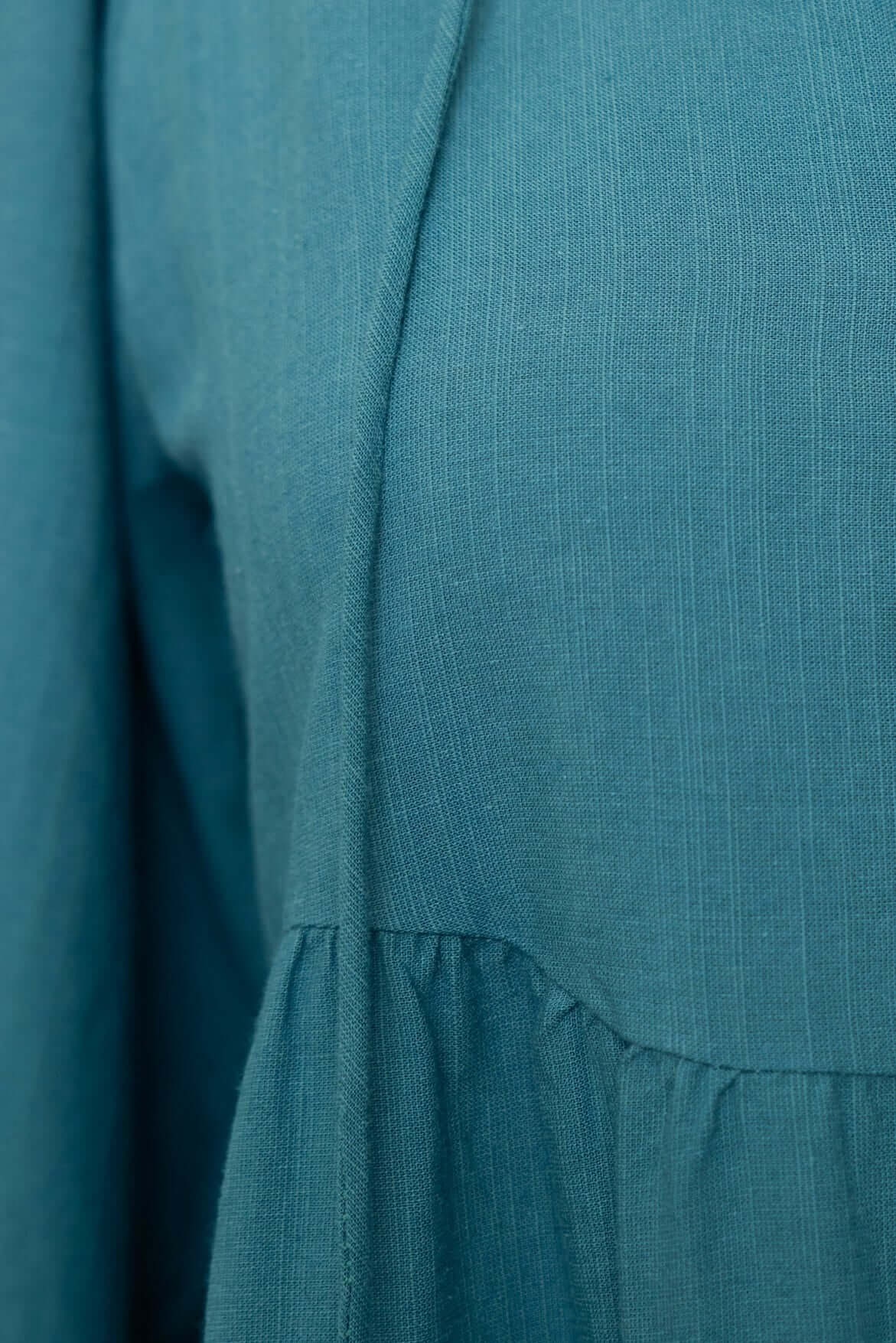 Close-up of Boone Dress showing textured fabric and relaxed fit, featuring a gathered hem and V-neckline.