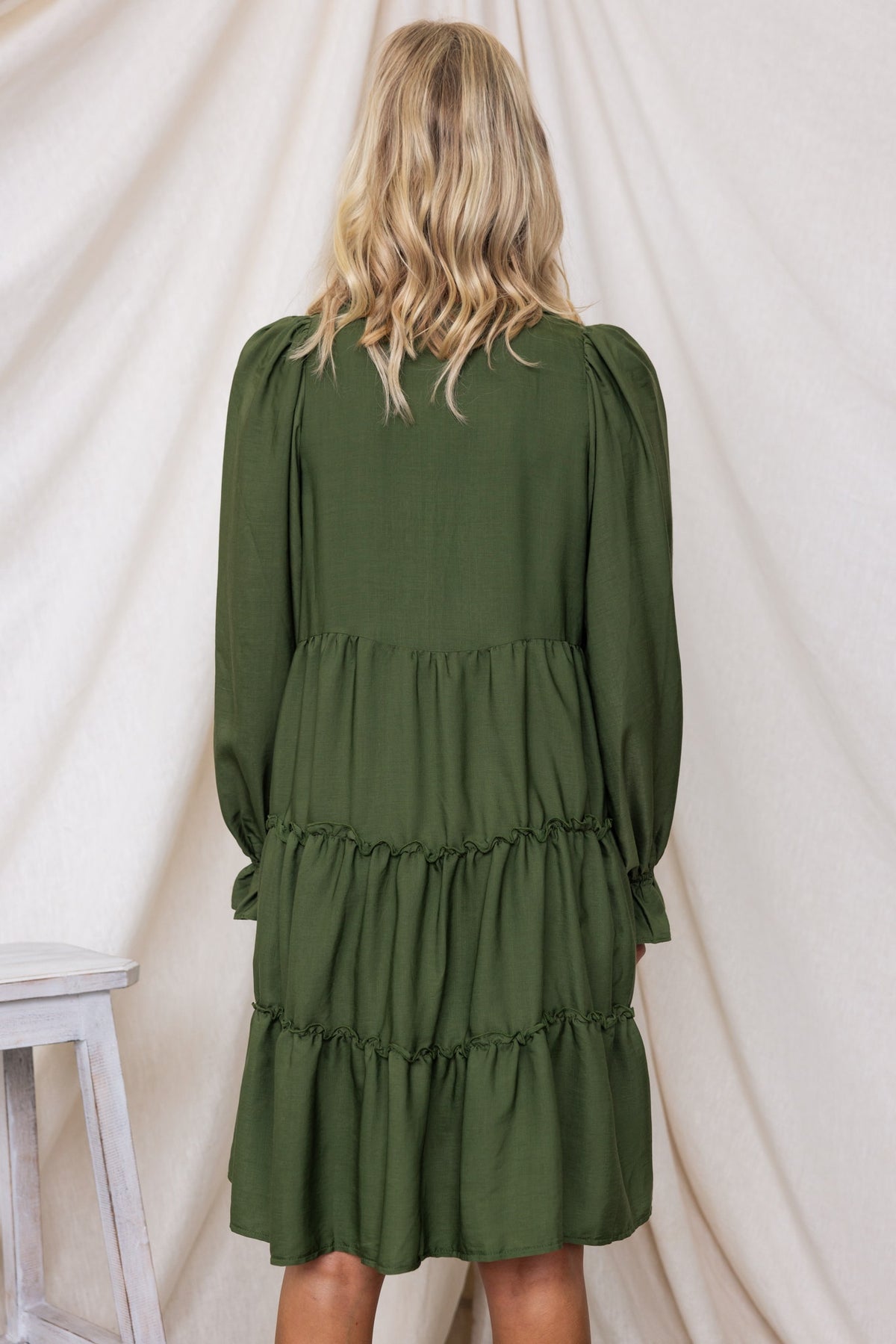 Back view of a relaxed-fit green Boone Dress with tiered design and puff sleeves.