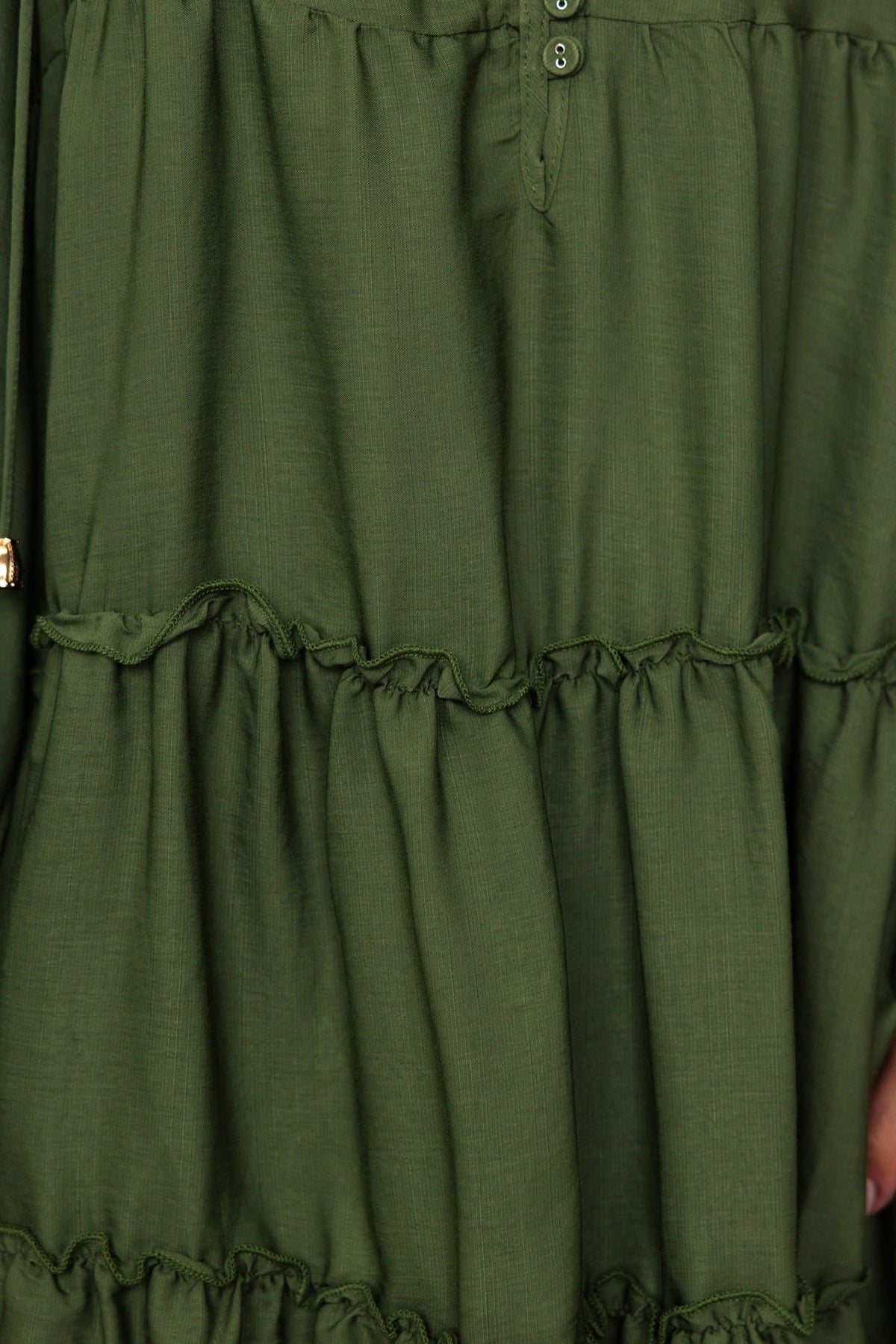 Close-up of Boone Dress in deep green with tiered ruffles and button detailing.