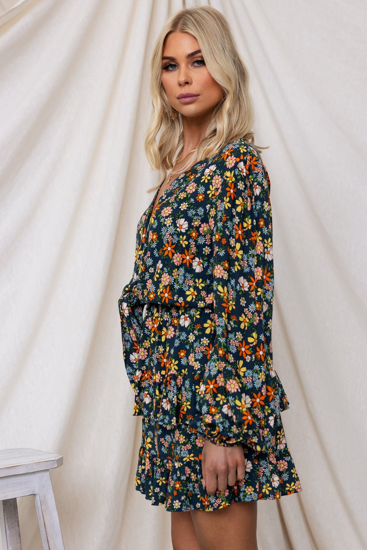 Model in Lanter Dress featuring floral print, V-neckline, and elastic details, styled against a neutral backdrop.