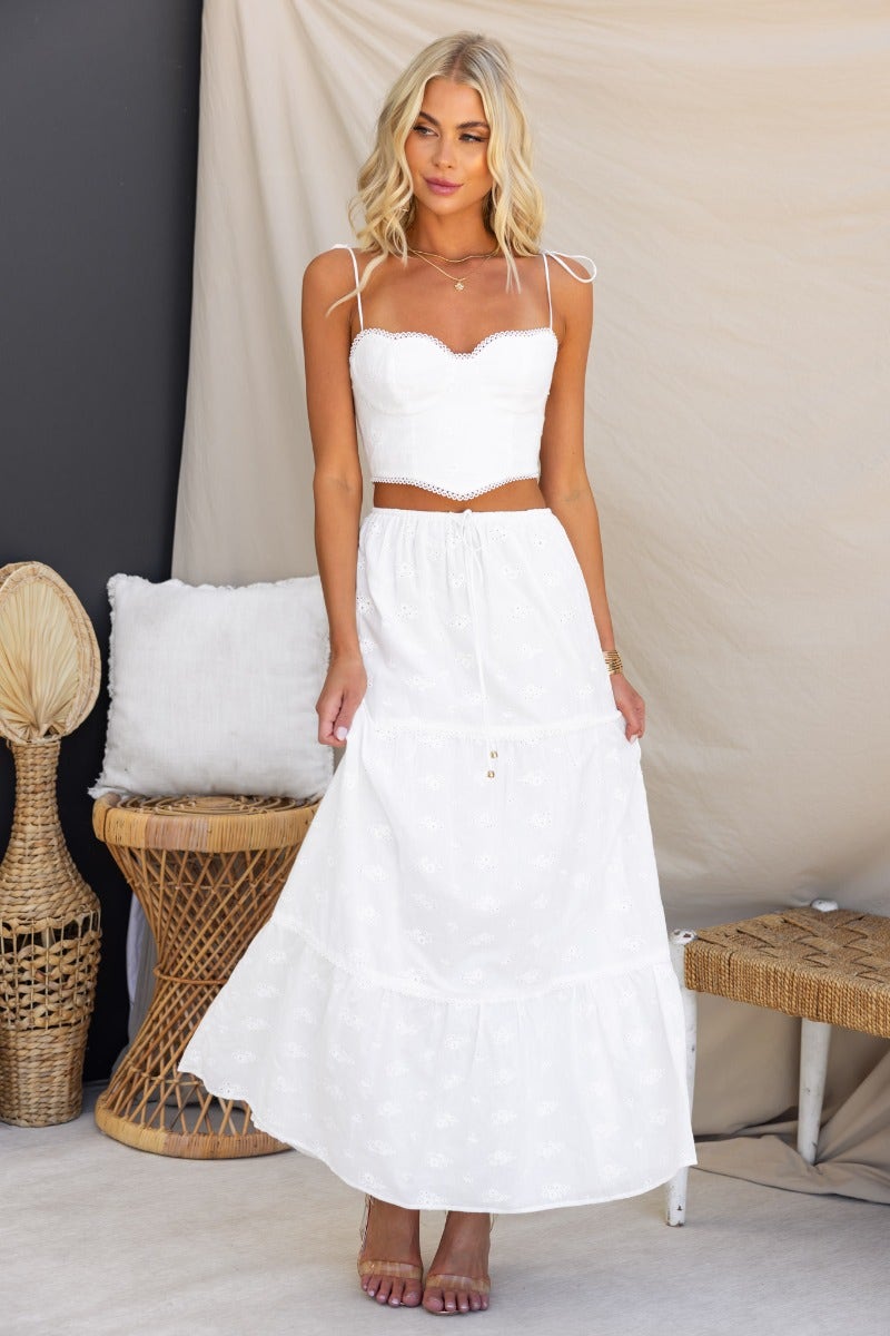 Model wearing a Long Live Maxi Skirt with elastic waistband and drawstring, paired with a white top, in a stylish setting.