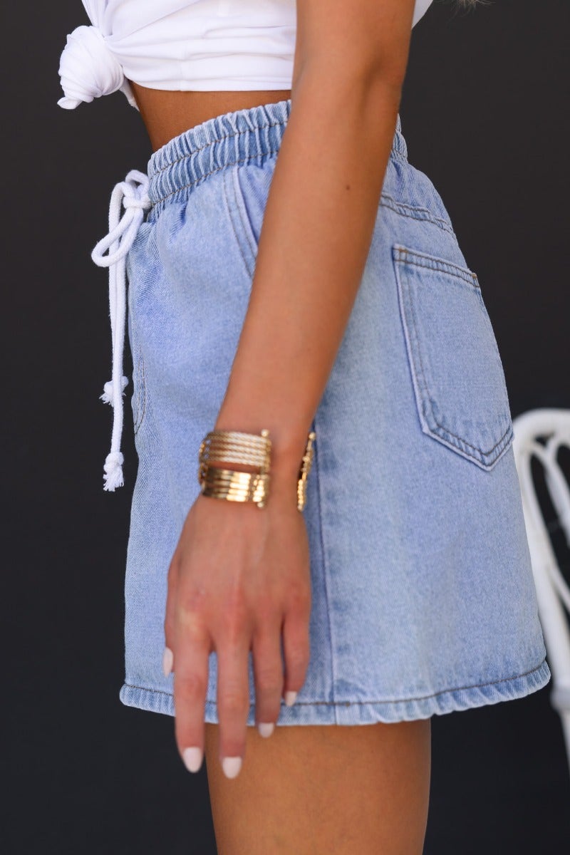 Serona denim skirt featuring elastic waistband and pockets, styled with a casual top.