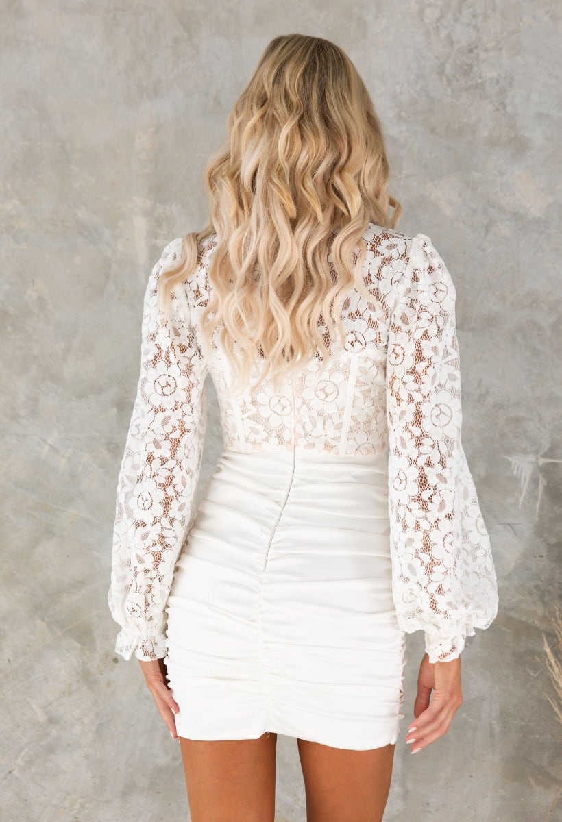Back view of Sweet Talker satin dress featuring a lace bodice, puff sleeves, and a ruched skirt.