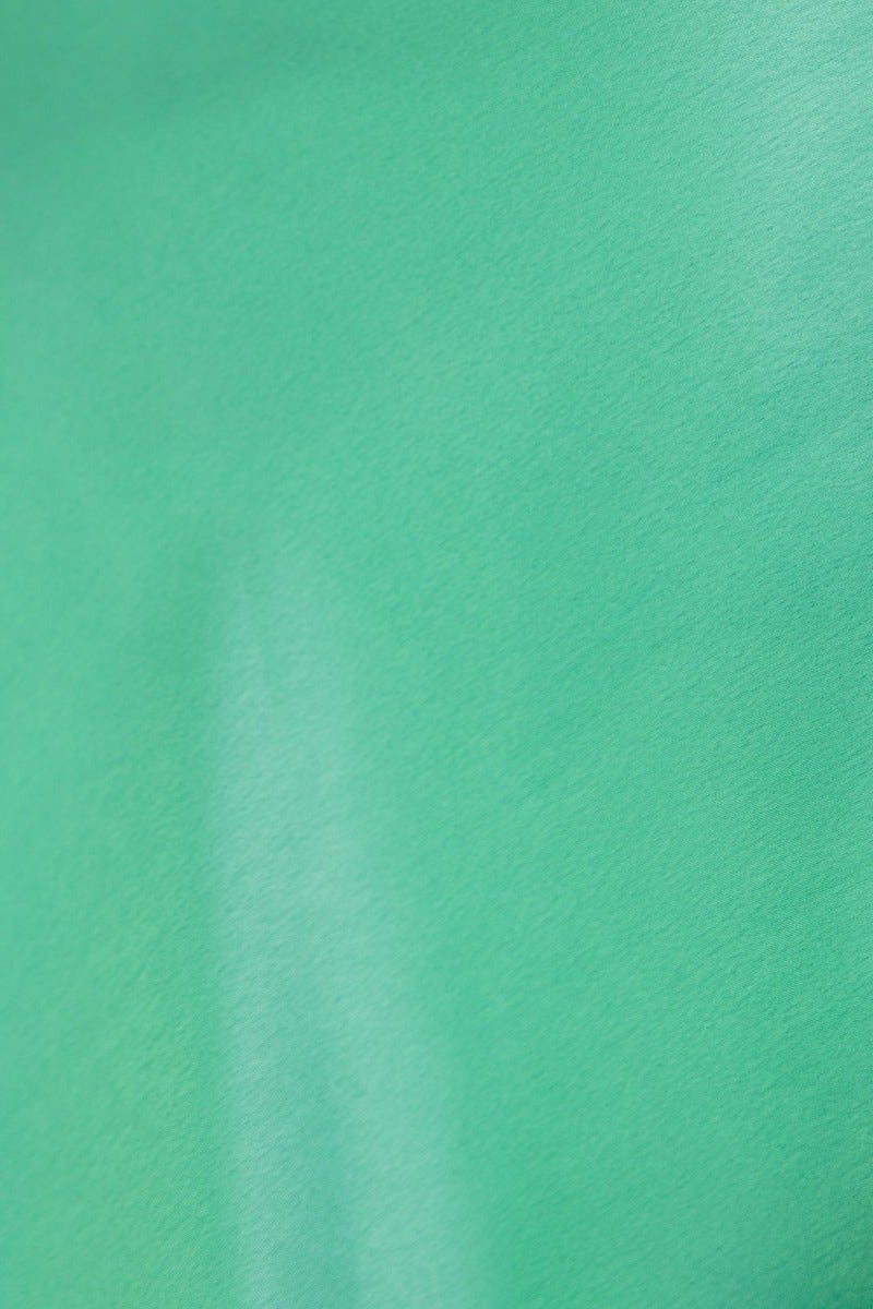 Close-up of a smooth satin fabric in a vibrant green color, showcasing its luxurious texture and sheen.