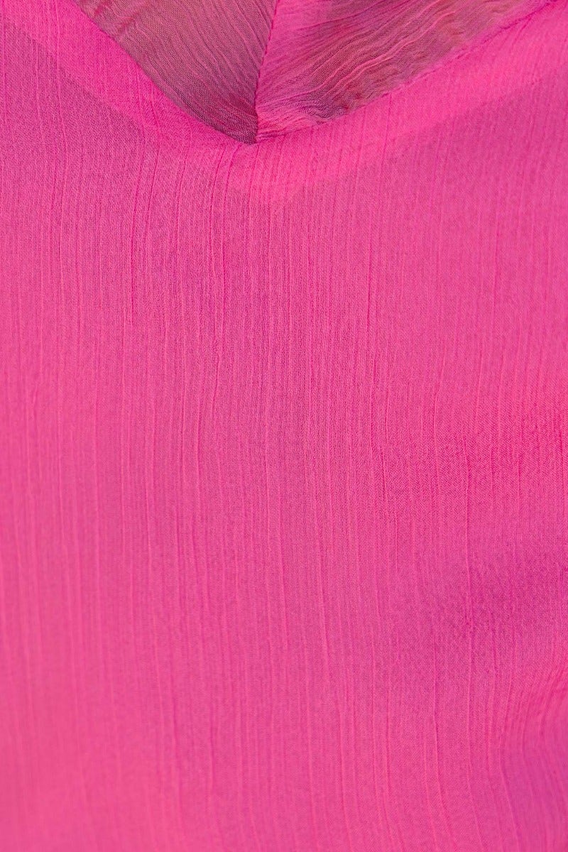 Close-up of vibrant pink chiffon fabric, showcasing its textured surface and rich color for the Encore Dress.