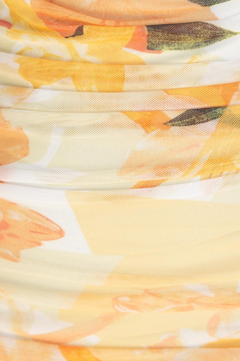 Close-up of floral fabric with yellow and orange hues, showcasing the texture of the Thousand Miles Midi Dress.