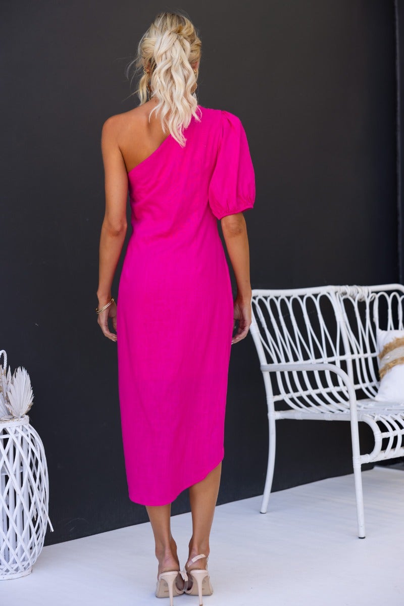 Back view of Last Kiss Midi Dress in bright pink, featuring one-shoulder neckline and asymmetric hem.