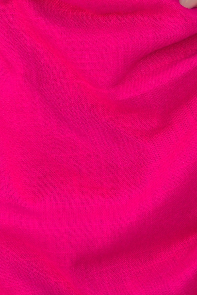 Close-up of bright pink linen fabric, showcasing smooth texture and vibrant color.