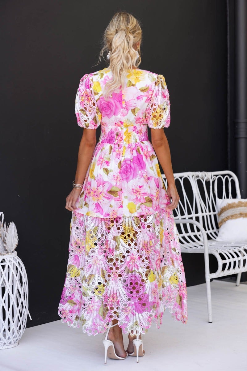 Model wearing a floral print Forever Free Maxi Dress with a V-neckline and puff sleeves, showcasing the back view.