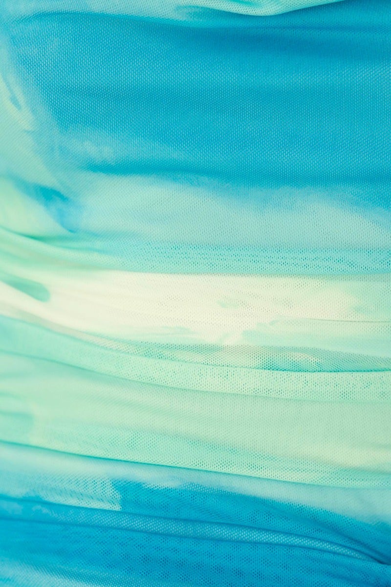 Close-up of ravishing midi dress fabric featuring a beautiful aqua and blue gradient with subtle ruching details.