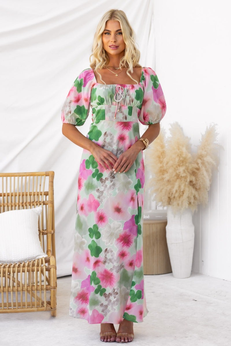 Model wearing Eyre Maxi Dress featuring floral print, elastic sleeves, and tie detail, set against a neutral background.