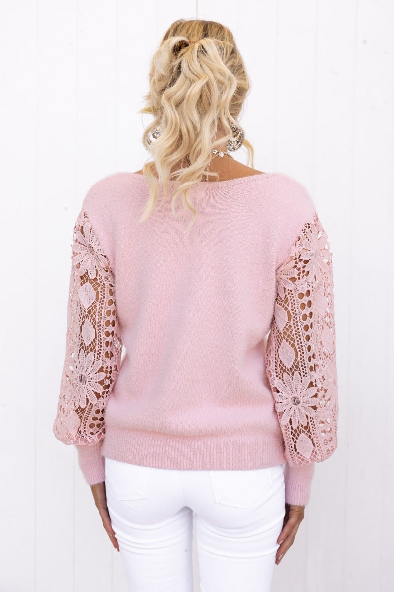 Back view of a pink Indya Jumper featuring fluffy knit fabric and lace sleeves, paired with white jeans.