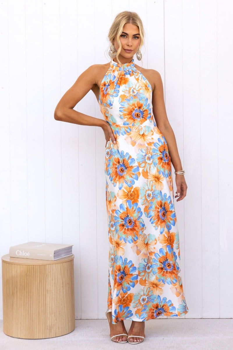 Model wearing a floral print satin maxi dress with high tie neckline and back zip, showcasing vibrant colors.