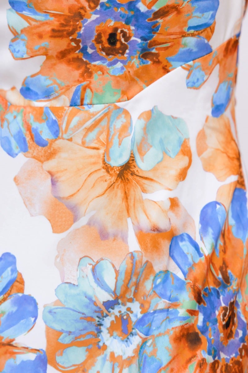 Close-up of floral print featuring orange and blue flowers on satin fabric of the Forbidden Love Maxi Dress.