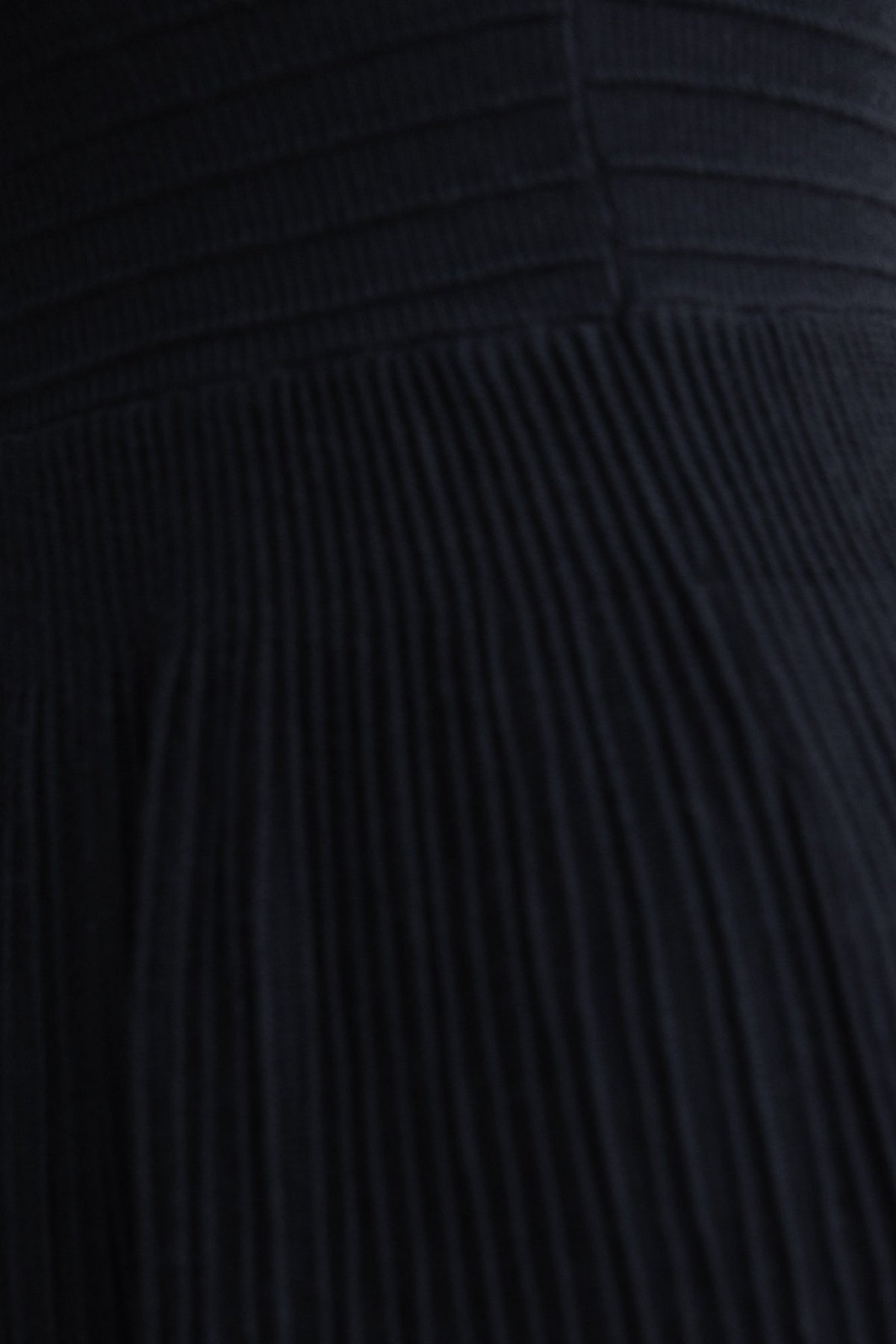 Close-up of the ribbed knit fabric of the Parkley Midi Dress in black with a textured appearance.