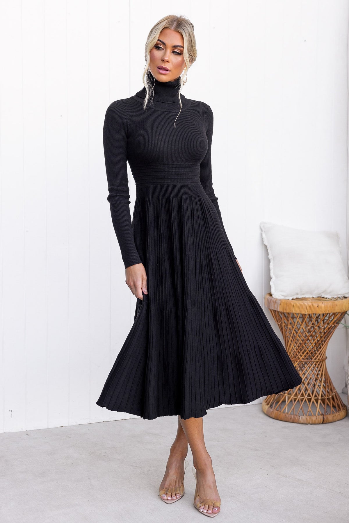 Chic black Parkley midi dress with turtle neckline and ribbed knit material, styled elegantly with a pleated skirt.