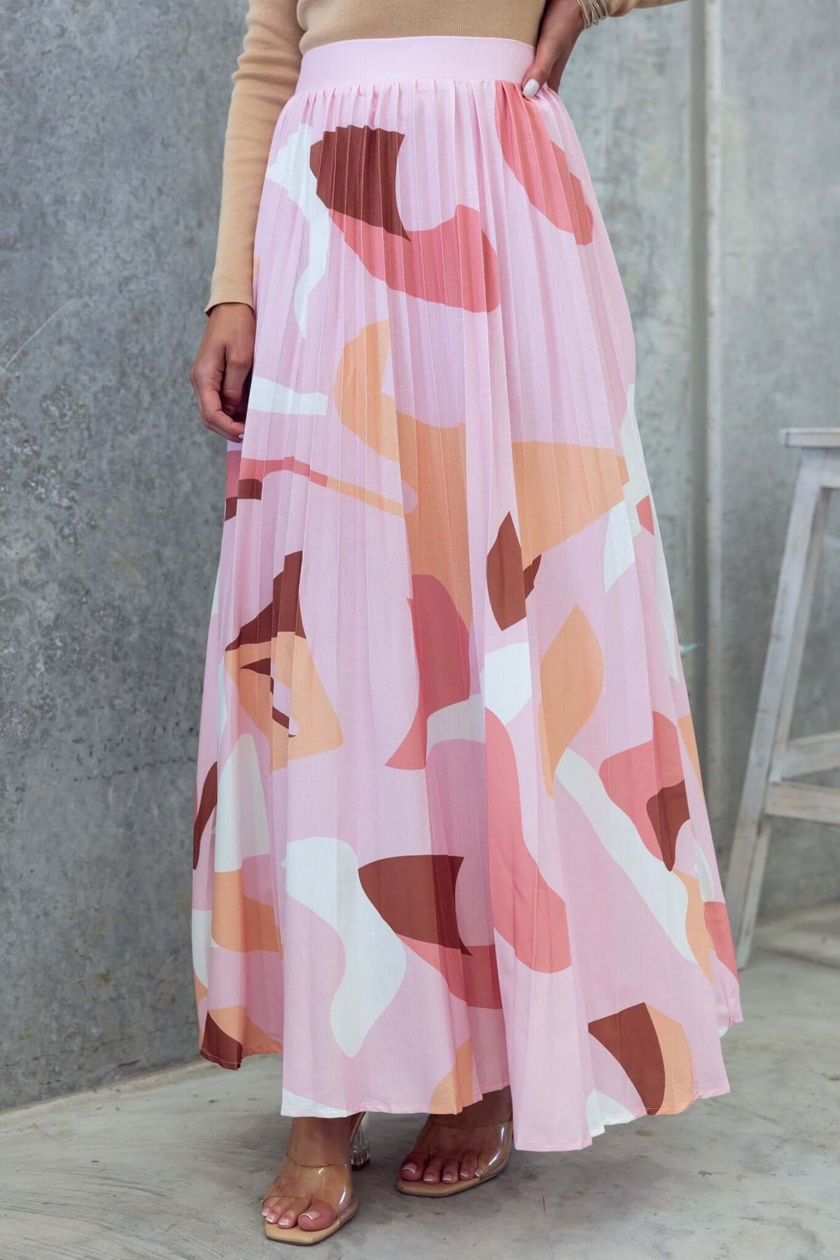 Bankston Maxi Skirt in pink and beige pleated fabric, featuring a mid-high waist and a flowy silhouette.
