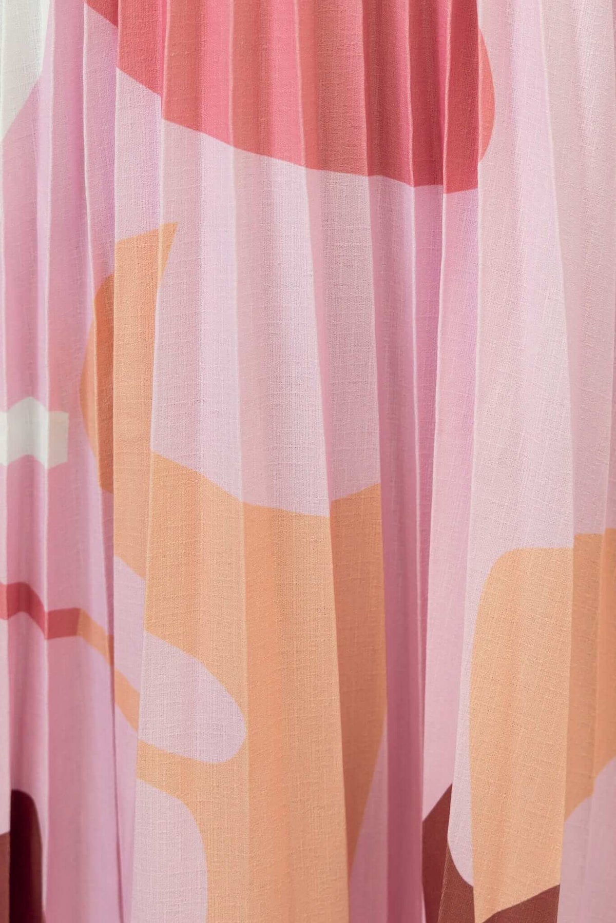 Close-up of pleated Bankston maxi skirt featuring a vibrant pink and pastel abstract pattern.