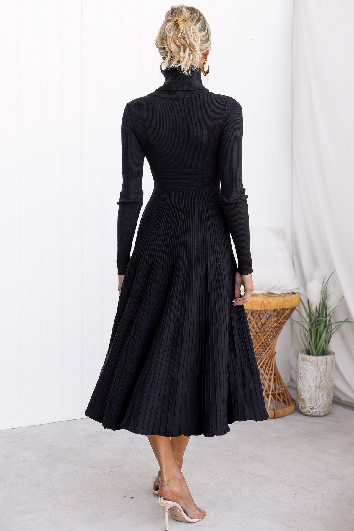 Back view of the black Parkley Midi Dress featuring a turtle neckline and pleated skirt.